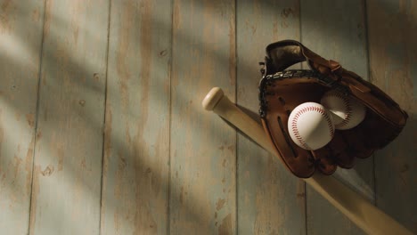 Overhead-Studio-Baseball-Still-Life-With-Bat-Ball-And-Catchers-Mitt-On-Aged-Wooden-Floor
